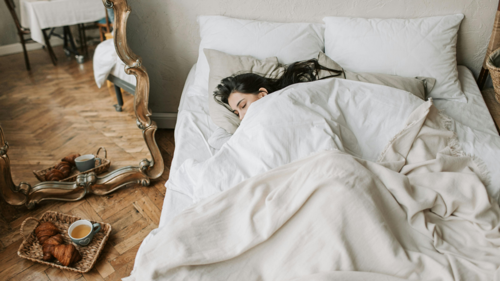 朝日が差し込む部屋のベッドで眠る女性の画像